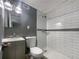 Updated bathroom with gray vanity, white toilet, and subway tile shower at 2492 Brentwood Ct, Decatur, GA 30032