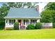 White house with green roof, red door, and wraparound porch at 3545 Liberty Rd, Villa Rica, GA 30180