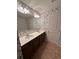 Bathroom with double vanity, white countertop, and nature-themed wallpaper at 231 Madison Ave, Acworth, GA 30102