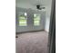 Spacious bedroom with carpet, two windows, and a ceiling fan at 4604 Shumart Dr, Snellville, GA 30039