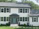 White two story house with dark shutters, gray roof, and stone accents at 4604 Shumart Dr, Snellville, GA 30039