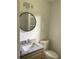 Bathroom with granite countertop, round mirror, and modern lighting at 4604 Shumart Dr, Snellville, GA 30039