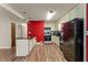 Kitchen with red accent wall, laminate wood floors, and black appliances at 146 Mount Bethel Rd, Mcdonough, GA 30252