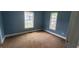 Empty bedroom with blue walls,carpet, and two windows at 2159 Martin Luther King, Jr. Dr, Atlanta, GA 30310