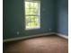 Empty bedroom with blue walls, brown carpet, and a window at 2159 Martin Luther King, Jr. Dr, Atlanta, GA 30310