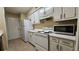 White kitchen cabinets, stove, microwave and refrigerator at 3010 Parc Lorraine, Lithonia, GA 30038