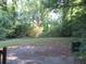 Wooded backyard with grassy area and a paved patio at 1142 Hembree Ln, Austell, GA 30168