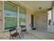 Covered front porch with brick exterior and two chairs at 2248 Annes Lake Cir, Lithonia, GA 30058