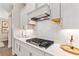 White kitchen features gas cooktop, custom cabinetry, and marble backsplash at 105 Summerlin Dr, Canton, GA 30115