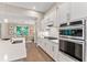 Bright kitchen with white cabinets, stainless steel appliances and hardwood floors at 105 Summerlin Dr, Canton, GA 30115