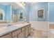 Bathroom features double sinks, light blue walls, and a tiled floor at 104 Streambank Ct, Temple, GA 30179
