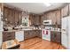 Kitchen boasts dark wood cabinets, brick backsplash, and stainless steel appliances at 104 Streambank Ct, Temple, GA 30179