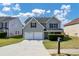 Two-story house with gray siding, two-car garage, and manicured lawn at 5908 Bluegrass Vw, Fairburn, GA 30213
