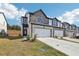 Two-story townhome with stone and white siding, two-car garage, and landscaping at 269 Bald Ave # 18, Stockbridge, GA 30253