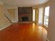 Living room with hardwood floors and stone fireplace at 1038 Ascot Ct, Riverdale, GA 30296