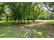 Open grassy yard with a gate and mature trees at 3651 Chandler Haulk Rd, Loganville, GA 30052