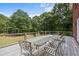 Deck with table and chairs, offering wooded backyard views at 3651 Chandler Haulk Rd, Loganville, GA 30052