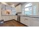 White kitchen with granite counters, stainless steel appliances, and hardwood floors at 303 Walnutwood Trl, Roswell, GA 30075