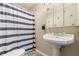Clean bathroom with pedestal sink, shower/tub combo, and striped shower curtain at 303 Walnutwood Trl, Roswell, GA 30075