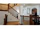 Elegant staircase with wrought iron railing and hardwood flooring, overlooking the dining area at 10785 Arlington Pt, Alpharetta, GA 30022
