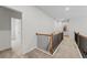 Upper hallway with carpeted flooring, showing access to bedrooms and laundry room at 255 Arwen Dr, Mcdonough, GA 30252