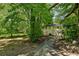 Spacious backyard with mature trees and a paved pathway at 1886 S Gordon Sw St, Atlanta, GA 30310