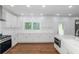 Spacious kitchen featuring white cabinets, stainless steel appliances, and hardwood floors at 1068 N Main Nw St, Conyers, GA 30012