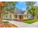 Charming yellow house with a front porch and driveway at 1068 N Main Nw St, Conyers, GA 30012