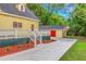 Yellow house exterior with detached garage, landscaping, and spacious driveway at 1068 N Main Nw St, Conyers, GA 30012