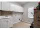 Laundry room with white cabinets and tile backsplash at 6159 Fernstone Nw Ct, Acworth, GA 30101