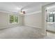 Bright bedroom with ceiling fan, plush carpeting, and ensuite bathroom access at 6159 Fernstone Nw Ct, Acworth, GA 30101