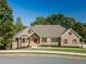 Brick house with a welcoming front porch and mature trees at 971 Heathchase Dr, Suwanee, GA 30024