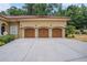 Three-car garage with attractive wooden doors and a large driveway at 1608 Golden Creek Sw Ct, Conyers, GA 30094