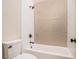 Clean bathroom with a tub and shower, featuring neutral tile at 1608 Golden Creek Sw Ct, Conyers, GA 30094