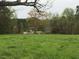 Open field with two houses visible in the distance at 410 Kilcrease Rd, Auburn, GA 30011
