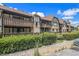Two-story building with brown wood exterior and manicured hedges at 112 Camelot Dr, Atlanta, GA 30349