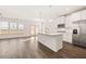 Modern kitchen with white cabinets, island, and stainless steel appliances at 1718 Lacebark Elm Way, Lawrenceville, GA 30045