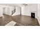 Open living room with hardwood floors, fireplace, and staircase at 1718 Lacebark Elm Way, Lawrenceville, GA 30045