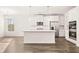 Open kitchen with white cabinets, island, and stainless appliances at 1718 Lacebark Elm Way, Lawrenceville, GA 30045