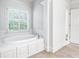 Spa-like bathroom with an oval soaking tub and window with shutters at 1440 Eugenia Ter, Lawrenceville, GA 30046