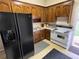 Galley kitchen with wood cabinets, stove, refrigerator and door to outside at 3355 Smithtown Rd, Suwanee, GA 30024