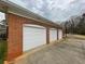 Brick three-car garage with white doors and ample driveway space at 3355 Smithtown Rd, Suwanee, GA 30024