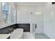 Modern bathroom featuring a standalone tub, glass shower, and marble tile at 1264 Six Sisters St, Dacula, GA 30019