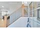 Bright foyer with hardwood stairs, black railing, and a glass front door at 1264 Six Sisters St, Dacula, GA 30019