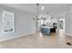 Open kitchen and dining area with hardwood floors, island, and modern light fixtures at 1264 Six Sisters St, Dacula, GA 30019