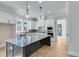 Modern kitchen featuring white cabinets, granite countertops, stainless steel appliances, and a large island at 1264 Six Sisters St, Dacula, GA 30019