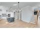 Kitchen and dining area with island, hardwood floors, white cabinets, and staircase at 1264 Six Sisters St, Dacula, GA 30019
