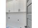 Laundry room with white cabinets, washer/dryer hookups, and gray door at 1264 Six Sisters St, Dacula, GA 30019