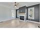 Living room with fireplace, dark accent wall, hardwood floors, and ceiling fan at 1264 Six Sisters St, Dacula, GA 30019