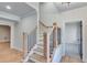 Light and bright staircase with wooden railing and black metal balusters at 1264 Six Sisters St, Dacula, GA 30019
